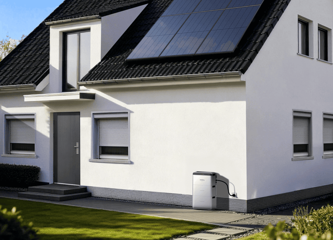 Jackery SolarVault 3 batterie solaire est branché sur une prise de la véranda, il y a des panneaux solaires sur le toit